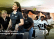 A group of smiling Kiaat Private Hospital staff members dancing and celebrating alongside community members for Mandela Day